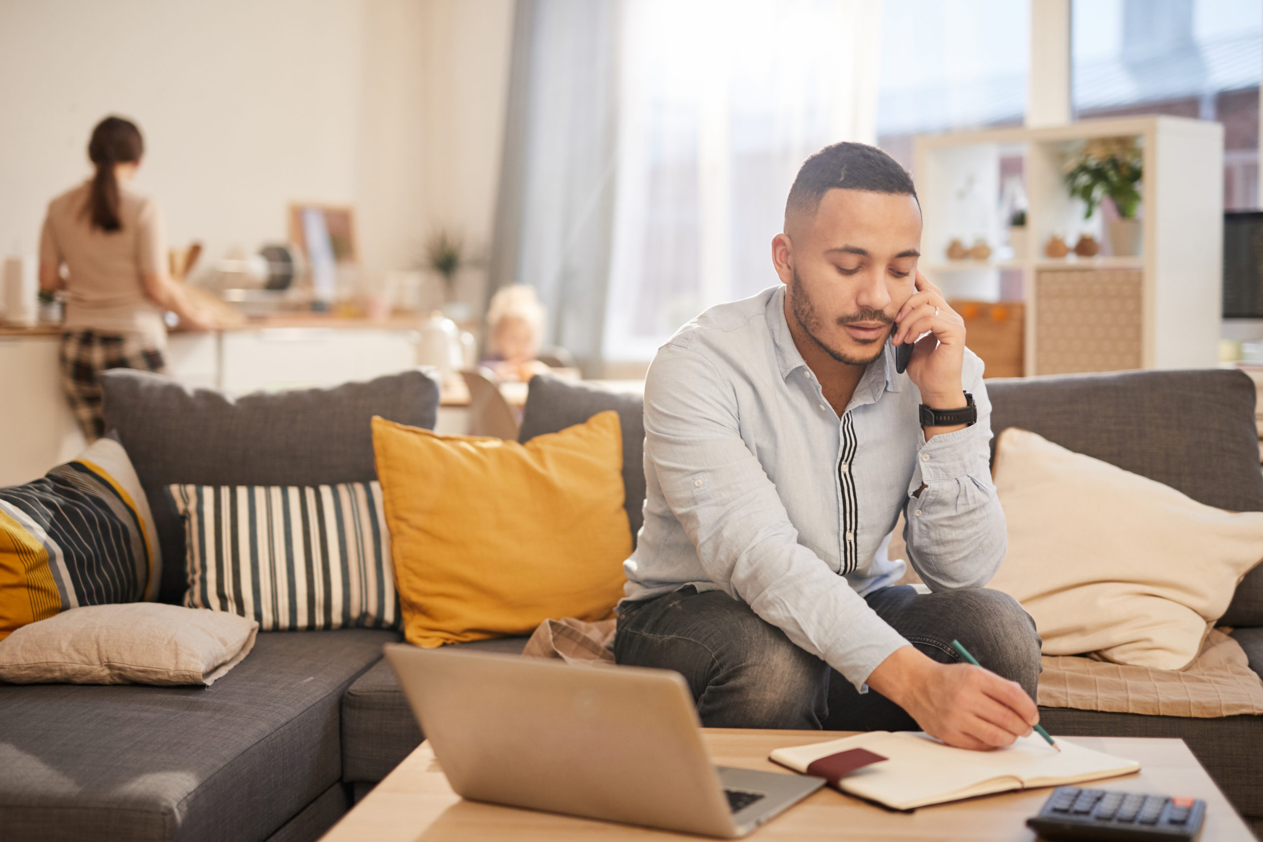 Modern Father Working from Home man on the phone using notebook