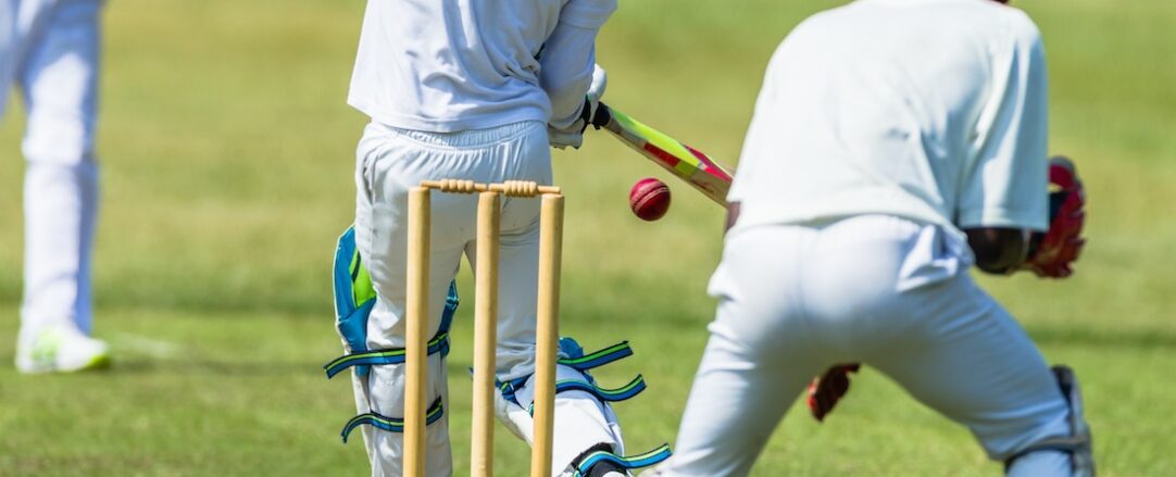 Cricket game action closeup unidentified abstract bowler batsman wicketkeeper.