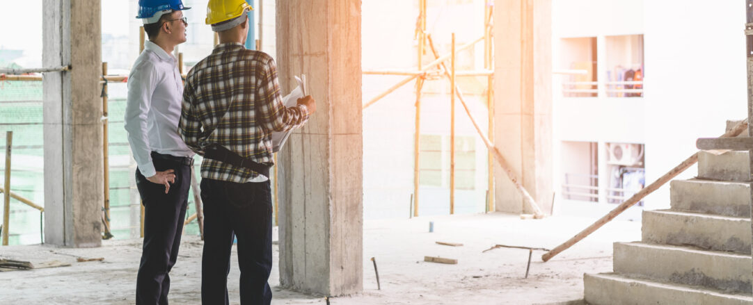 Asian contractor and engineer inspecting material in construction building.